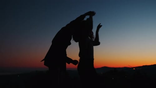 Silhouetted Couple Dancing Joyfully at Sunrise