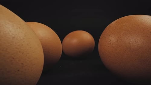Mehrere frische braune Eier aus Freilandhaltung. Dazwischen läuft die Kamera vorbei. Dolly wurde mit einer Makrosondenlinse aufgenommen
.
