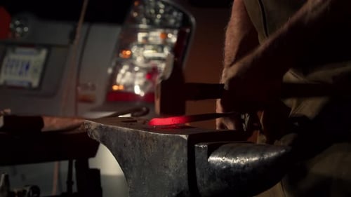 Closeup of Blacksmith in Apron Working with Hammer and Iron in the Workshop