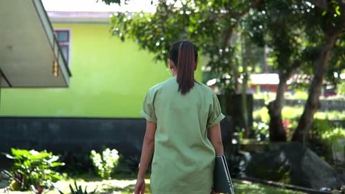 Nurse Walking Slowly at Small Village Clinic Outdoors