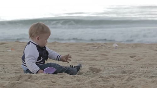 Baby Playing on a Sandy Beach With Waves