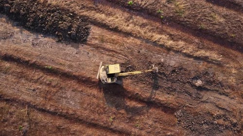 Aerial view of a wheel loader excavator with a backhoe loading sand into a heavy earthmover