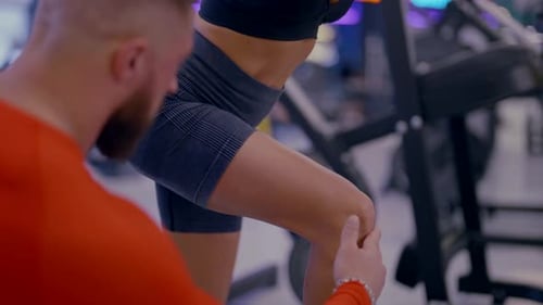 Training with Coach in Gym Beautiful Slender Woman Doing Squats in Fitness Club Details of Body