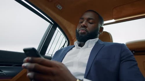 Focused Man in Luxury Car Using Mobile Phone