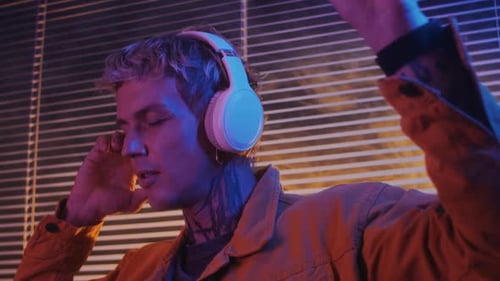 Man with Tattoos Listening to Music and Dancing