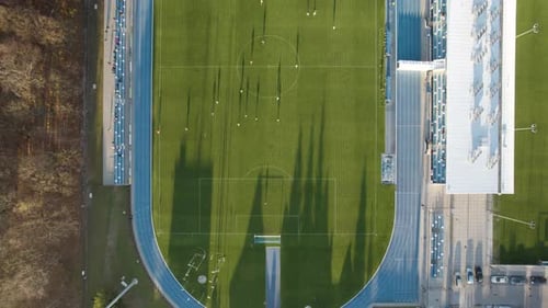 Aerial top-down shot of the soccer stadium during the football match with few spectators due to the