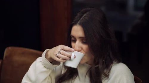 Portrait of a Content Italian Woman Sitting Quietly Outside a Cafe Drinking