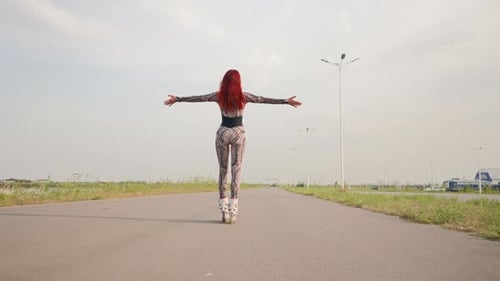 Woman Roller Skating on Paved Road, Arms Outstretched