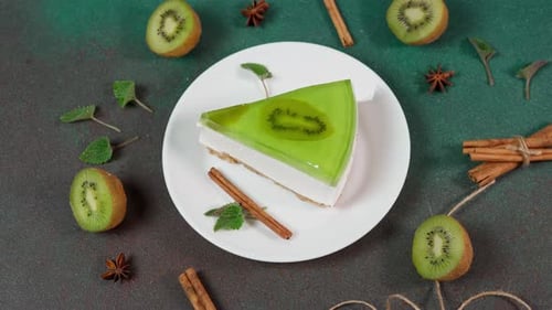 Close up of Homemade Cheesecake with Kiwi in a white plate on a Green background