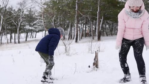 Happy Mother and Son Play Snowballs Throw Powder in the Woods on Frosty Winter Day Woman and Boy