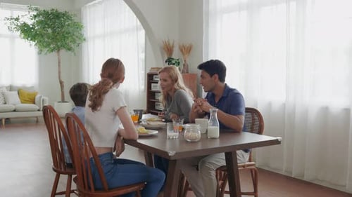 Family Eating Breakfast Together and Conversing at Home