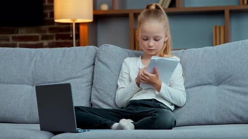 Blonde Girl on Couch Studying with Laptop and Notebook