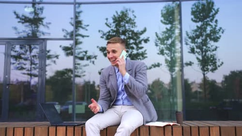 Man Talking on Phone Outside Office Building