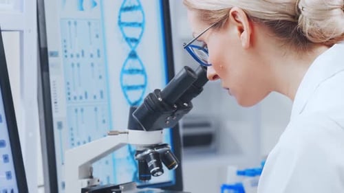 Woman Uses Microscope in Bright Lab Environment