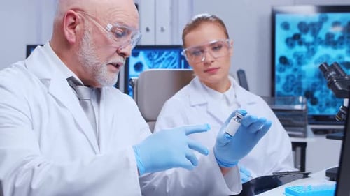 Scientists Discussing Medical Vial in Modern Laboratory