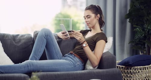 Woman shops online while relaxing on couch