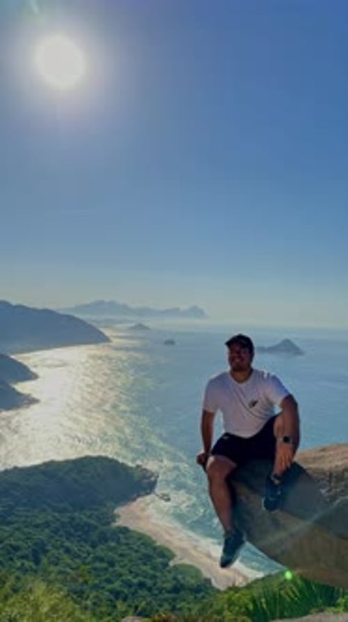 Wide shot of a male rock climber descending down a rock face