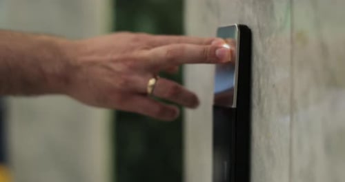 Mann drückt Aufzugsknopf in einem modernen Gebäude oder Hotel Männlicher Finger drückt den Liftknopf
