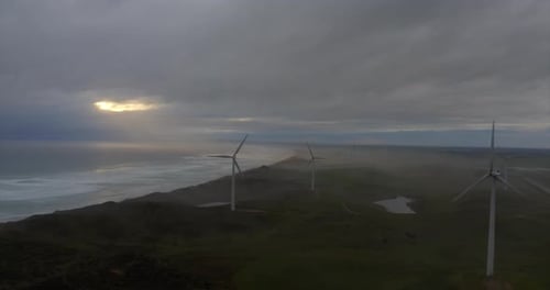 Aerial shot of wind mills rotating by the force of the wind and generating renewable energy in a g