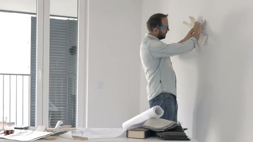 Man Choosing Paint Colors for Interior Wall