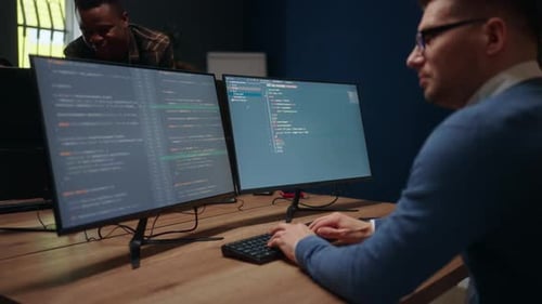 Database Architect is Writing Computer Code View Through Shoulder on Display Male Data Scientist