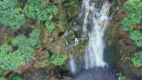 Aerial drone footage of a tall rocky waterfall in the Yorkshire Dales, Pennies. Moorland scene of a