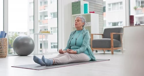 Senior Woman Meditating on Yoga Mat at Home
