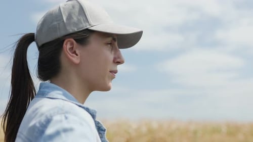 Happy Female Farmer Standing in the Middle of a Bright Open Agricultural Field