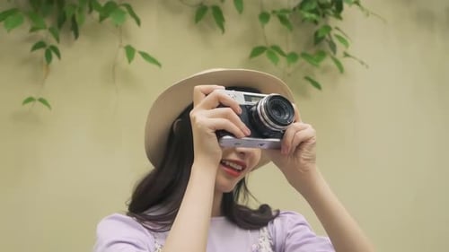 Woman Smiling and Taking Photos with Camera Outdoors