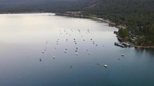 A high-flying, 4K drone shot over anchored boats during a summertime sunset, off the coast of Lake T