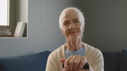 Senior Woman Smiling and Holding Walking Stick Indoors