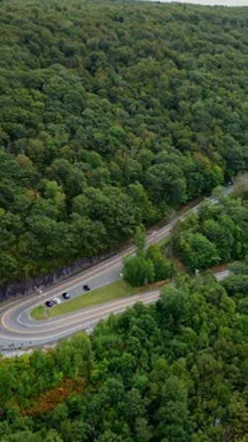 Cars driving along a sharp hairpin curve on the scenic Mohawk Trail in the Berkshire Mountains of