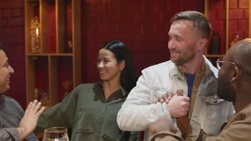 Friends Gathering Together in Pub and Talking Happily