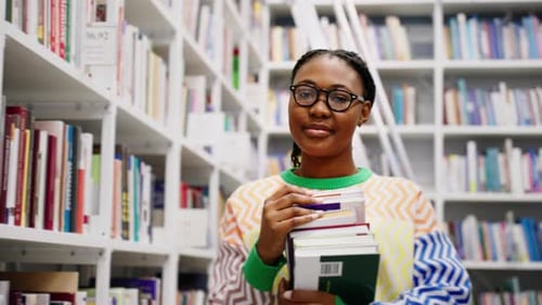 Portrait of African American Female Student with Books in the Library