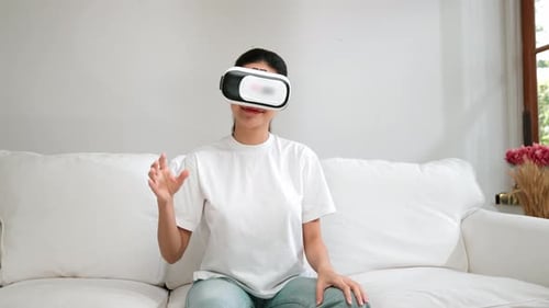 Woman Sitting on Couch Wearing Virtual Reality Headset
