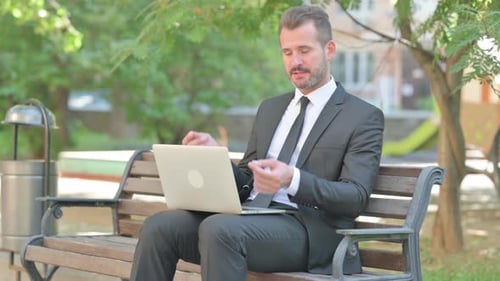Business Man Video Call on Laptop in Park