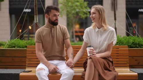 Couple Holding Hands and Talking on Park Bench