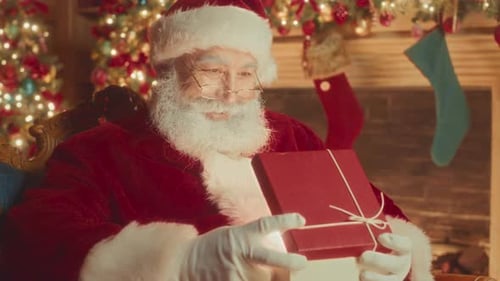 Santa Claus Holding Magical Glowing Christmas Gift