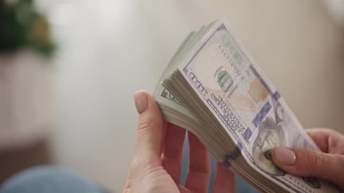 Woman Shuffling Stack of One Hundred Dollar Bills