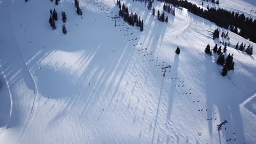 Aerial view of People Skiing and snowboarding on hill, Ski Resort. Drone flies over Skiers Skiing do