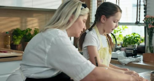 Kochen, Backprozess: Erfreute Vorschulkind-Tochter Enkelin am Morgen beim Zubereiten