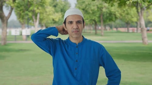Confused Muslim man thinking about something in park
