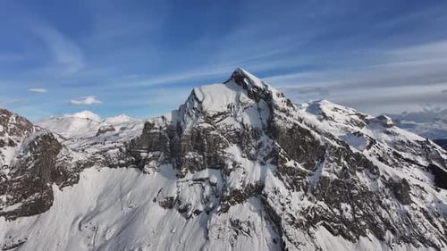 pic de Fronalpstock enneigé avec des falaises escarpées et un ciel bleu clair à Glaris Nord, en Suisse
