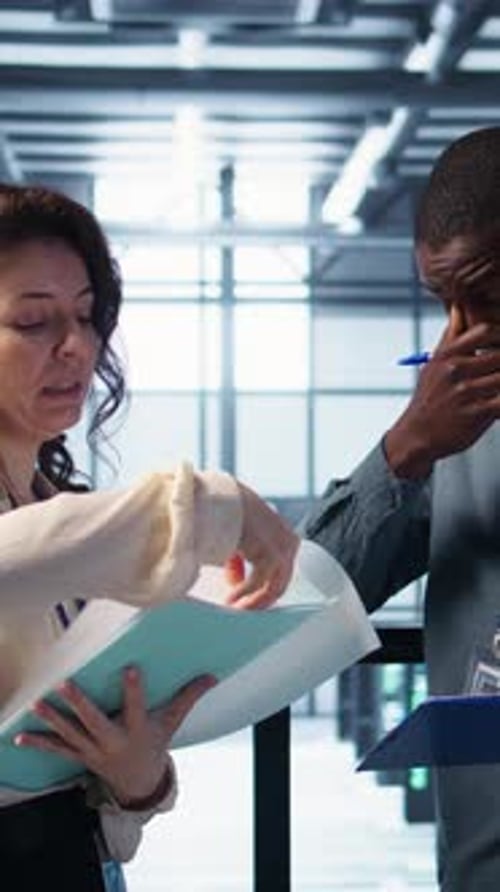 Vertical Video Team of IT Professionals Looking Over Data Center Checkup Checklist Paperwork