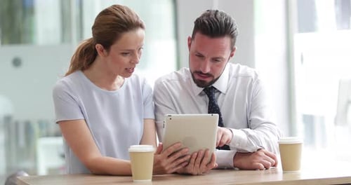 Colleagues using a digital tablet in a meeting