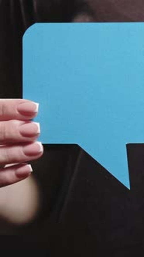 Hand Holding Up Blue Speech Bubble Close Up