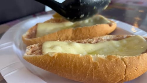 Assembling fresh toast with melted cheese, close up