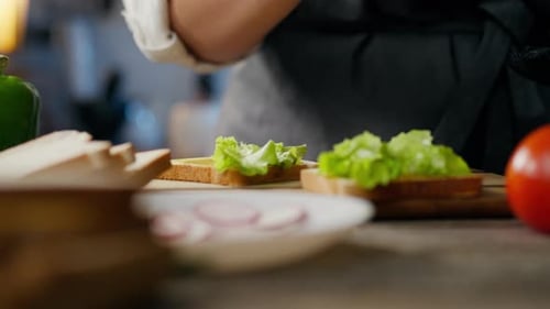 Close-up Sandwich Preparation with Lettuce