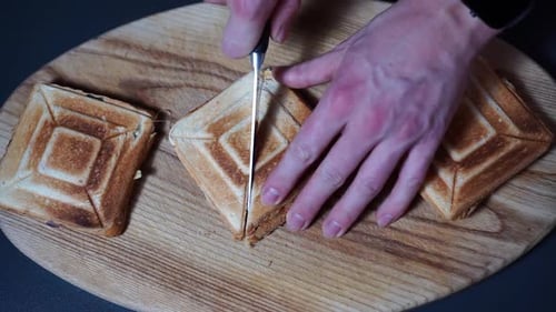 Top View Of Toasted Cheese Sandwich Being Cut Into Halves And Pressed. overhead shot