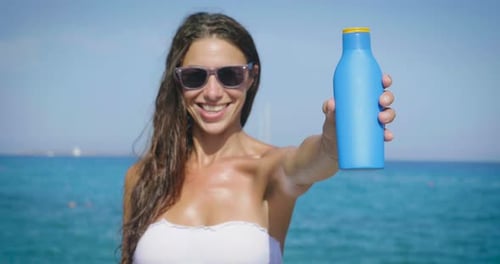 una chica en el mar usa protector solar para proteger la piel e hidratar la piel. concepto de cremas para s